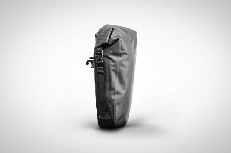 Tailfin 5L Mini Pannier in black, edge-on studio view showing its roll-top closure and X-clamp mounting hook.