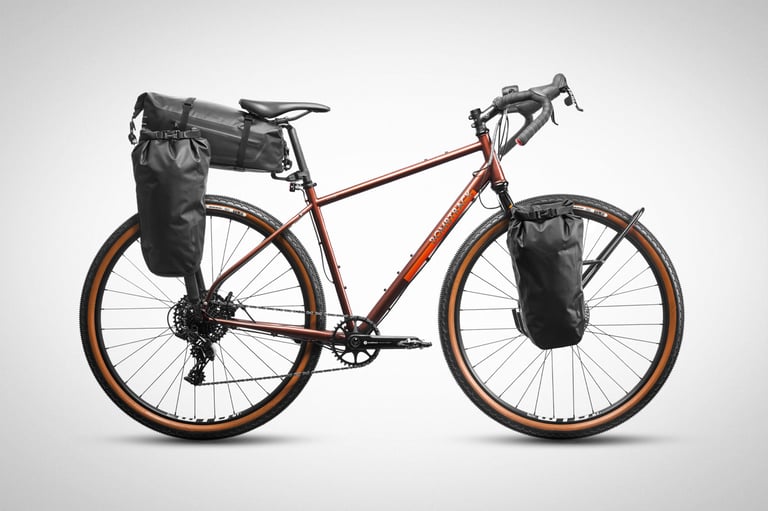 Copper Bombtrack gravel bike on white with Tailfin Mini Panniers on the rear rack and fork, and a pack behind the saddle.