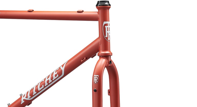 Ritchey Ascent frame in Sierra Red on white, close-up of the head tube, fork crown and top tube mounts.