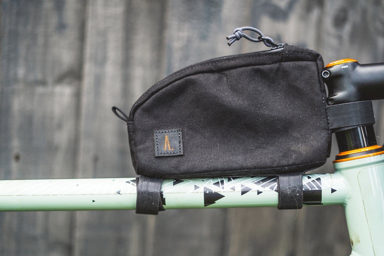 Ashdown Bags top tube bag in black canvas, held on a pale green frame by Velcro straps beside the stem.