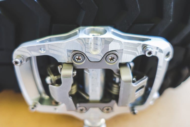 Hope Union Trail pedal propped against a knobbly tyre, face-on view of the sprung cleat clips and platform.