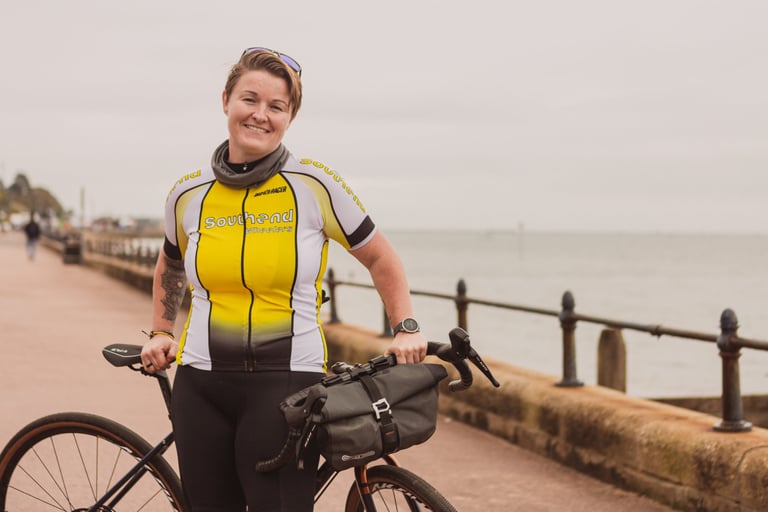 Mel Lamb in Southend Wheelers kit holds her Marin gravel bike, fitted with a handlebar bag, on the Southend promenade.