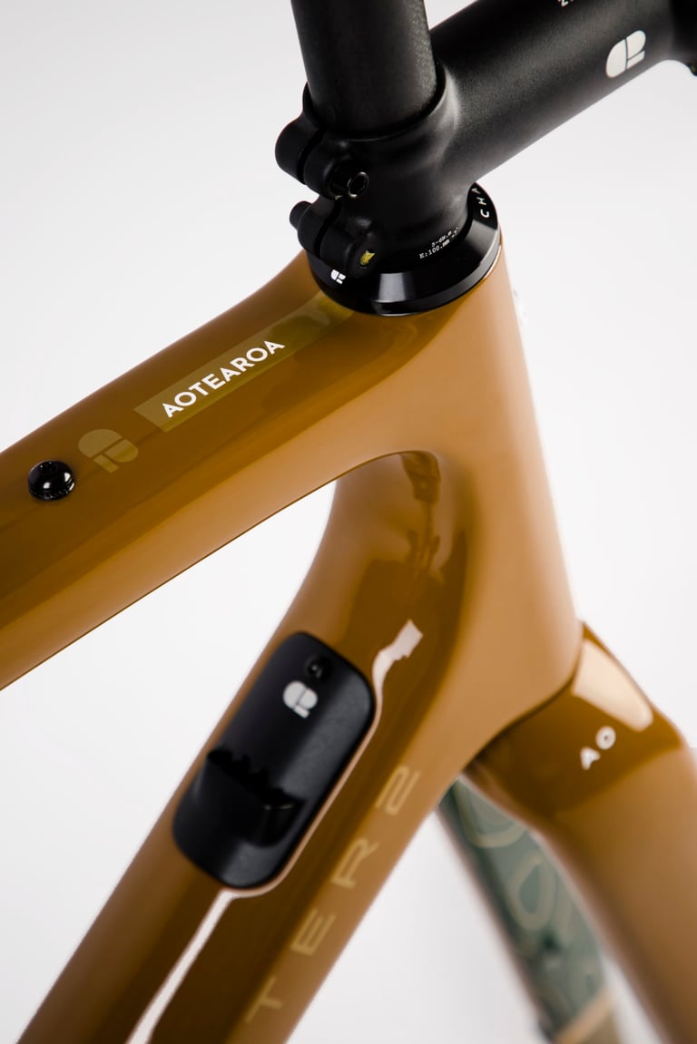 Chapter2 AO top tube with an Aotearoa decal and the internal cable routing port on the down tube below the stem.