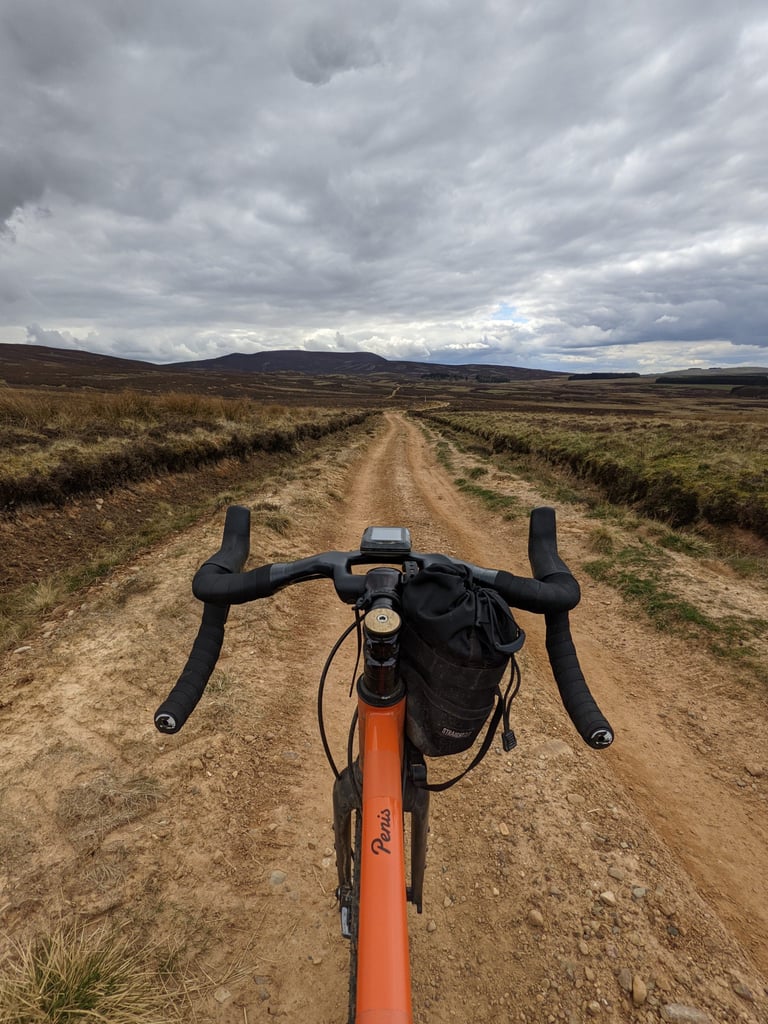 View over the bars of a Fairlight Secan with a stem bag along the dry, rutted Yellow Brick Road across Pentlands moorland.