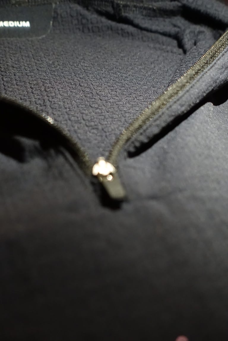 Inside of the POC Mantle hoodie at the quarter zip, showing the lining of small raised O shapes that trap air.