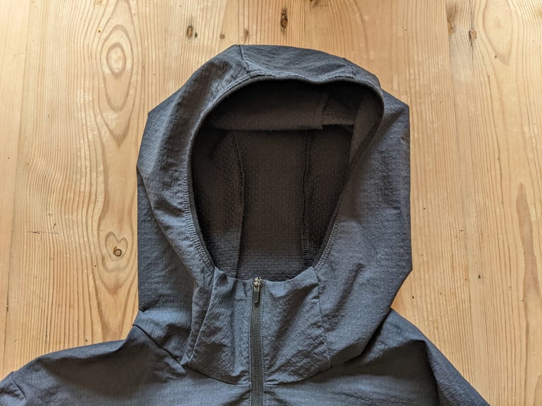 Hood of the POC Mantle hoodie laid flat on a wooden surface, with soft edging and quarter zip.