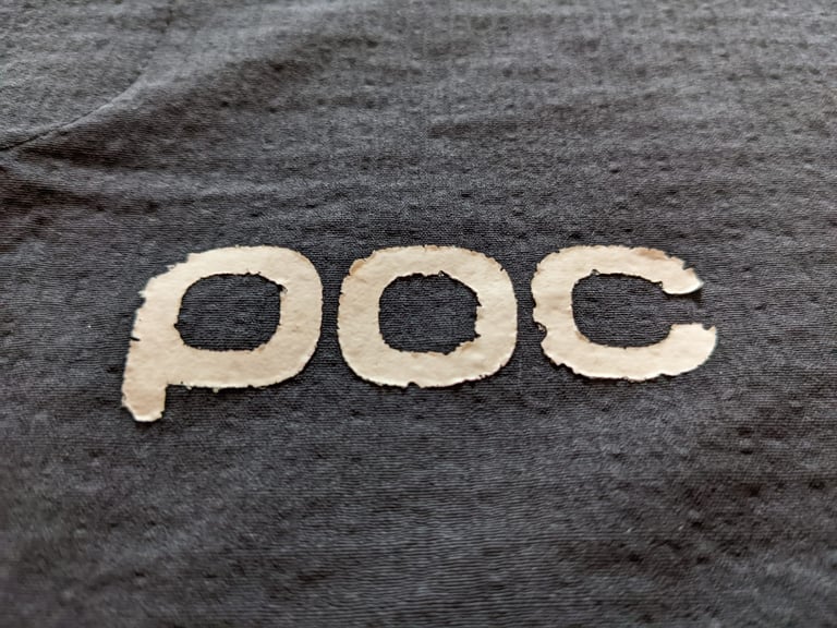 Rear POC logo on the Mantle hoodie, peeling and cracked at the edges after wear.