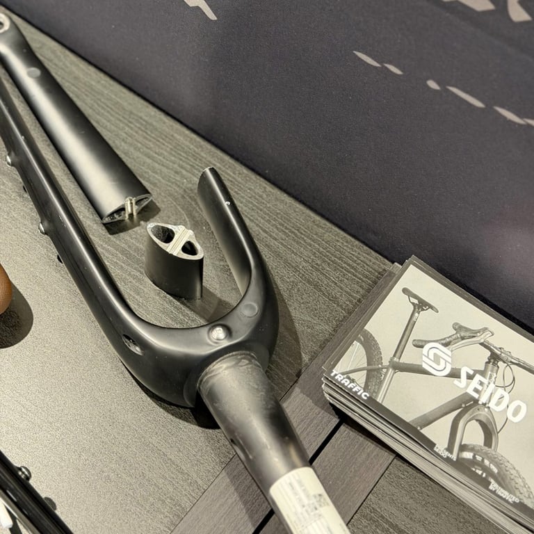 Cutaway Seido carbon fork on a trade show stand, the leg sectioned to show the moulded-in mounting bosses.