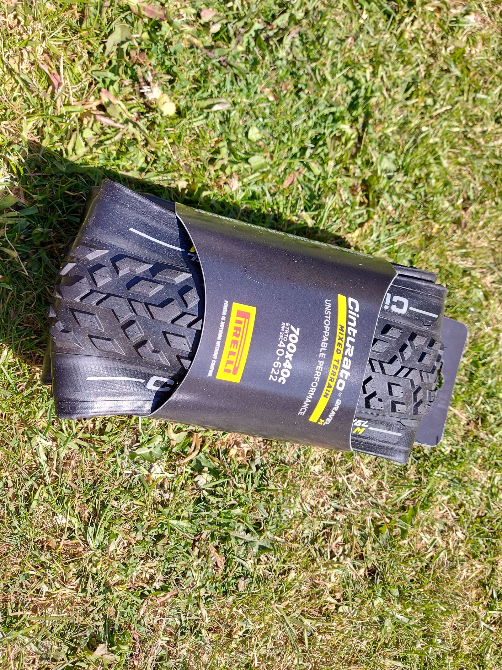 A boxed Pirelli Cinturato Gravel tyre lying on grass